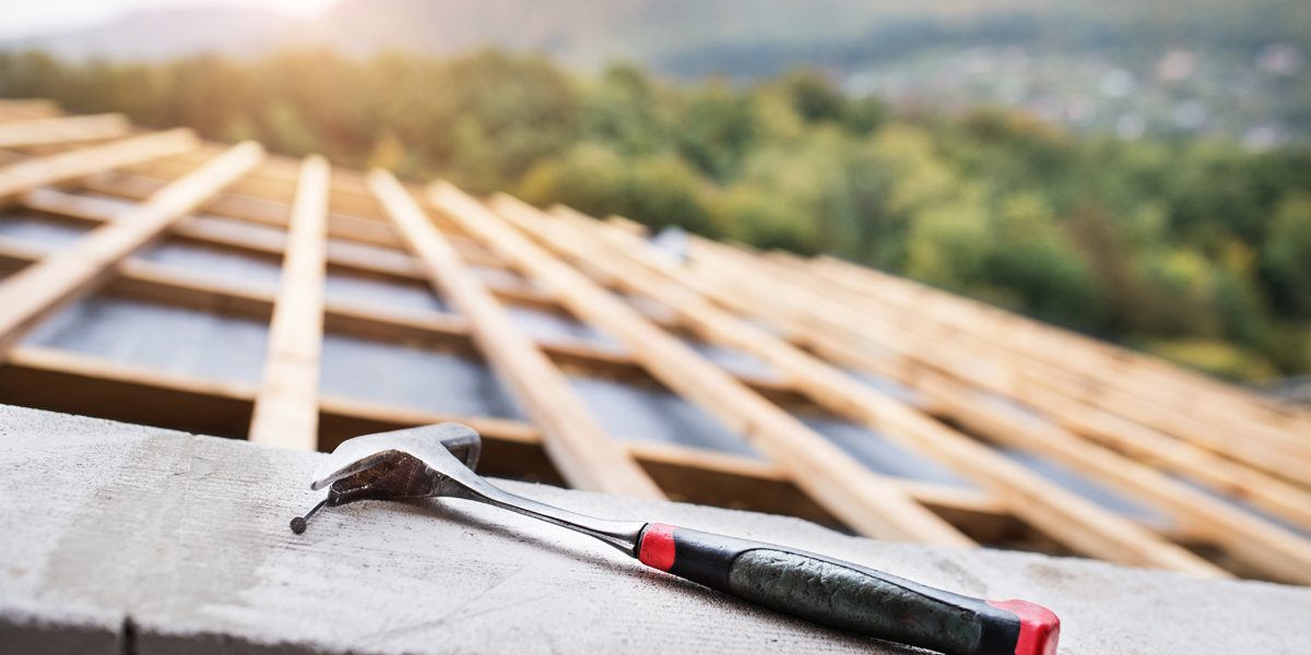 Hammer on the roof on the construction site.